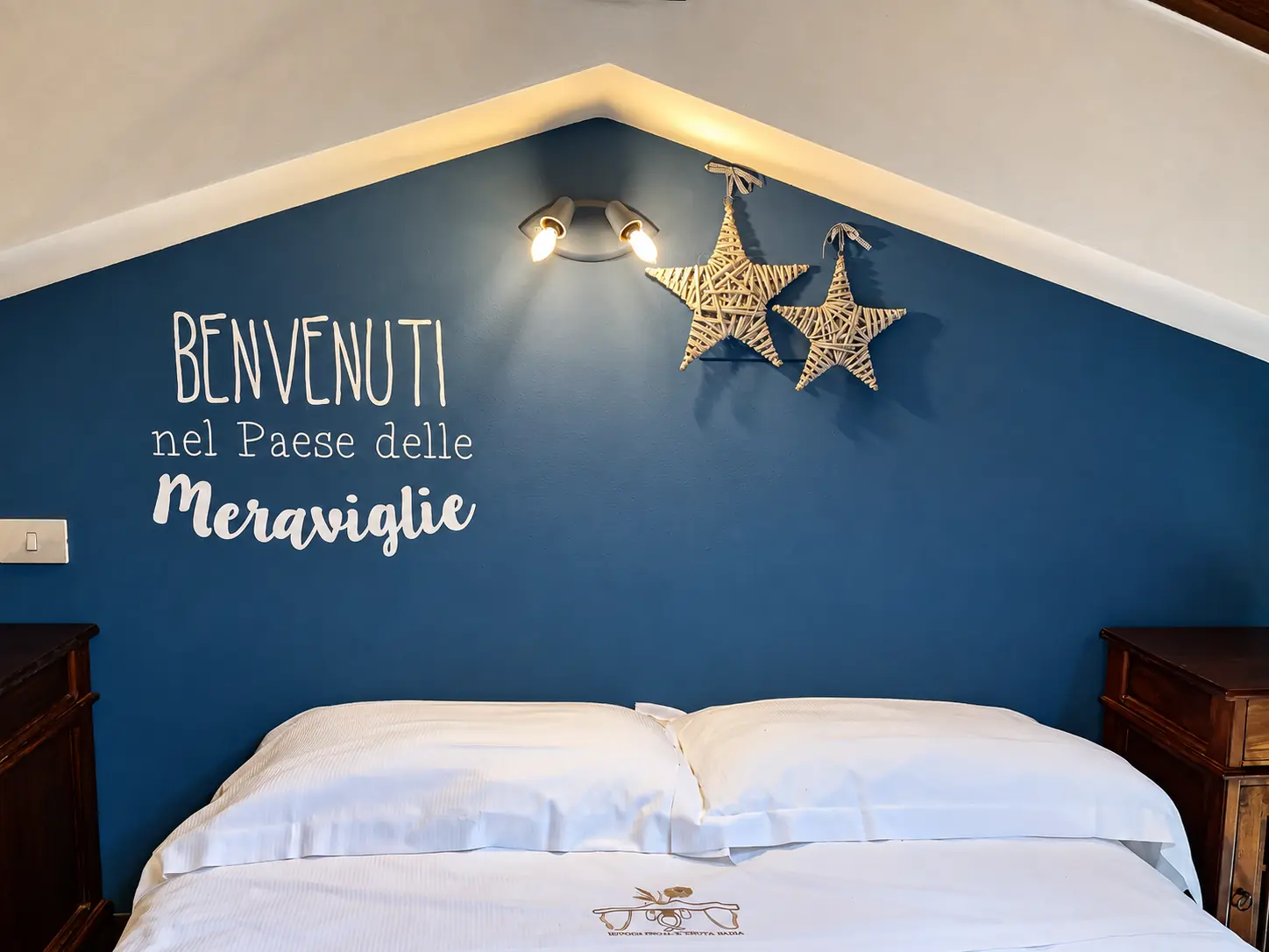 Blaue Schlafzimmerwand in Il Perugino mit Willkommensschriftzug und dekorativen Sternen
