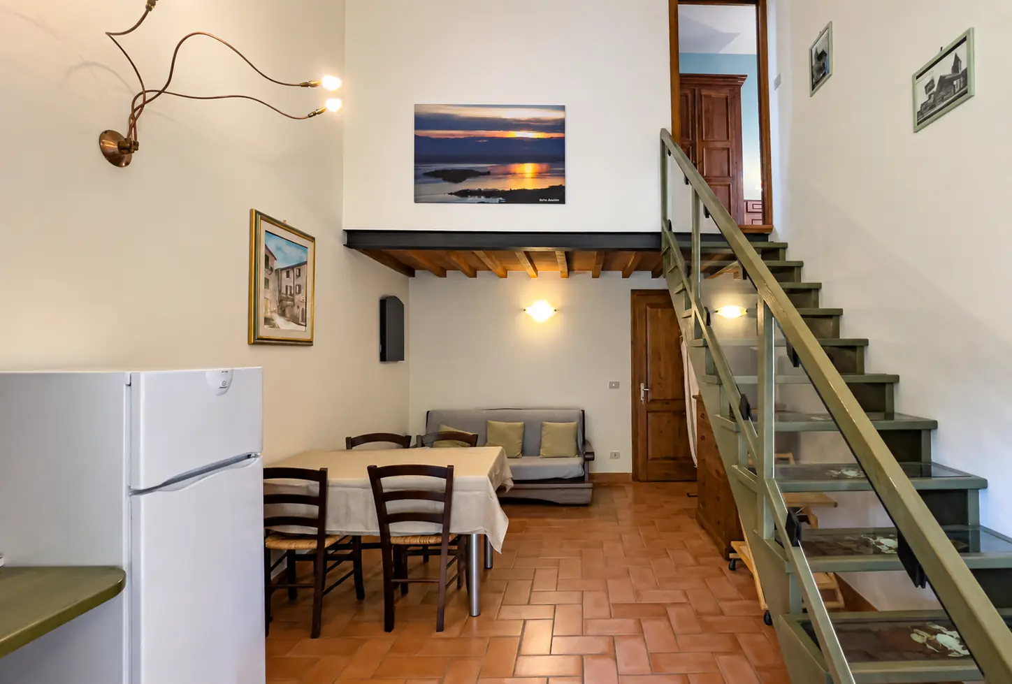 Isola Maggiore: Essbereich, Sofa und Treppe zum Obergeschoss