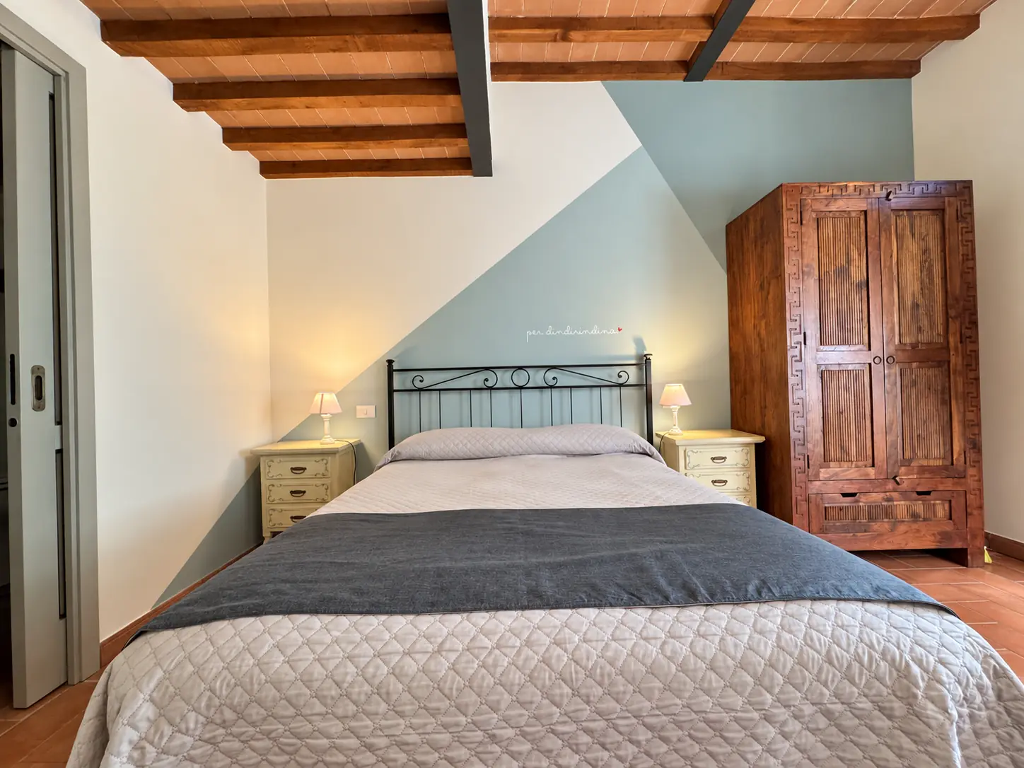 Camera Isola Minore: letto matrimoniale e arredi in legno a Tenuta Badia