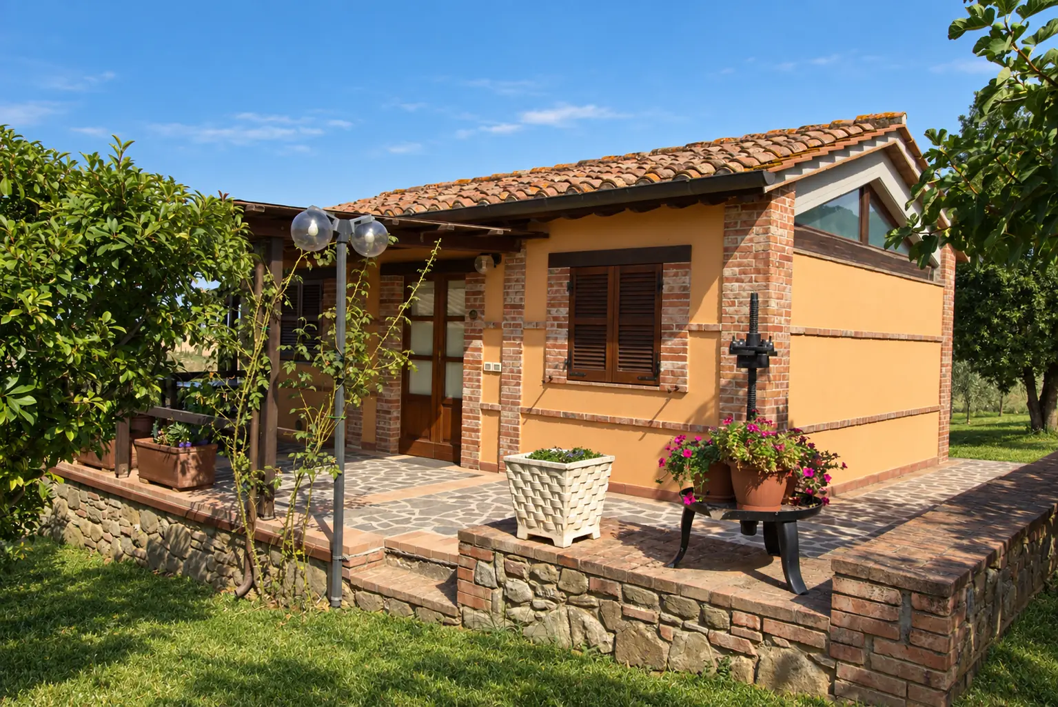 La Capanna auf der Tenuta Badia mit überdachter Terrasse, Garten und ockerfarbener Fassade