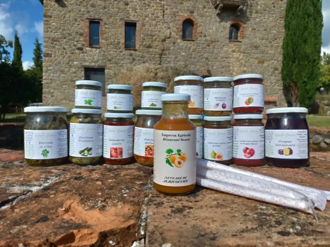 Produits conditionnés de la ferme Bianconi Sonia présentés devant une maison en pierre