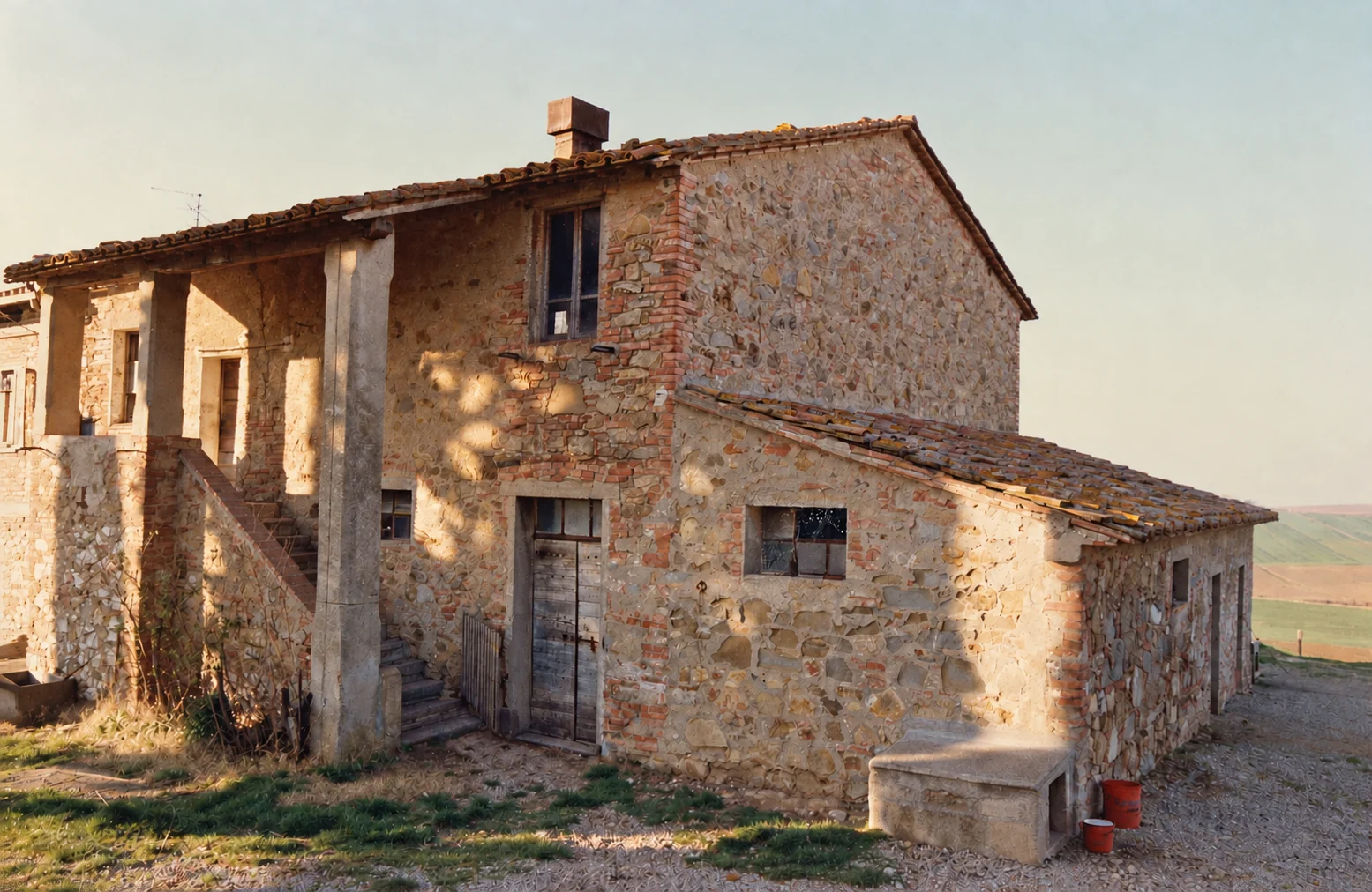 Foto storica del casale Belvedere Badia a Paciano, con facciata in pietra, scala esterna e annesso rurale