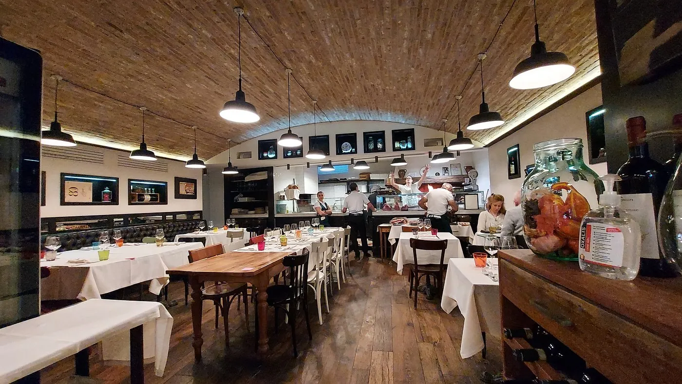 Salle du restaurant Bruno Coppetta, avec tables dressées et plafond voûté en briques