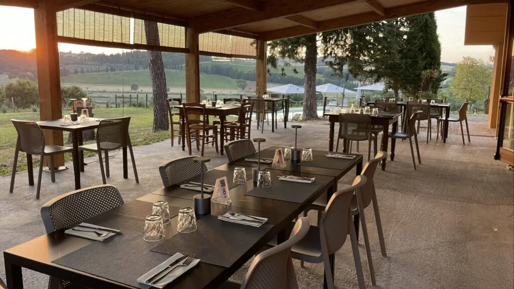 Terrazza coperta del ristorante Il Favaio, con tavoli apparecchiati e vista sulla campagna