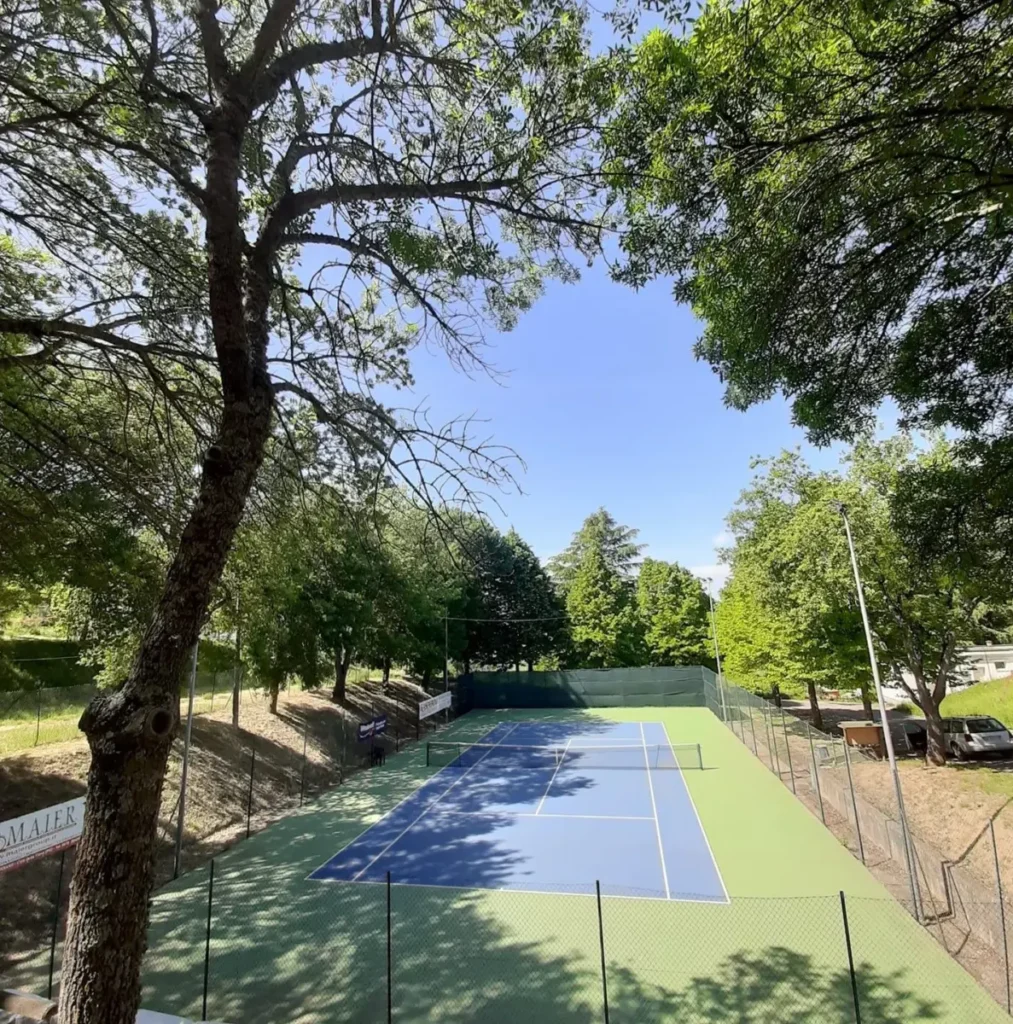 Campo da tennis di Paciano visto dall’alto, con pini e alberi lungo la recinzione