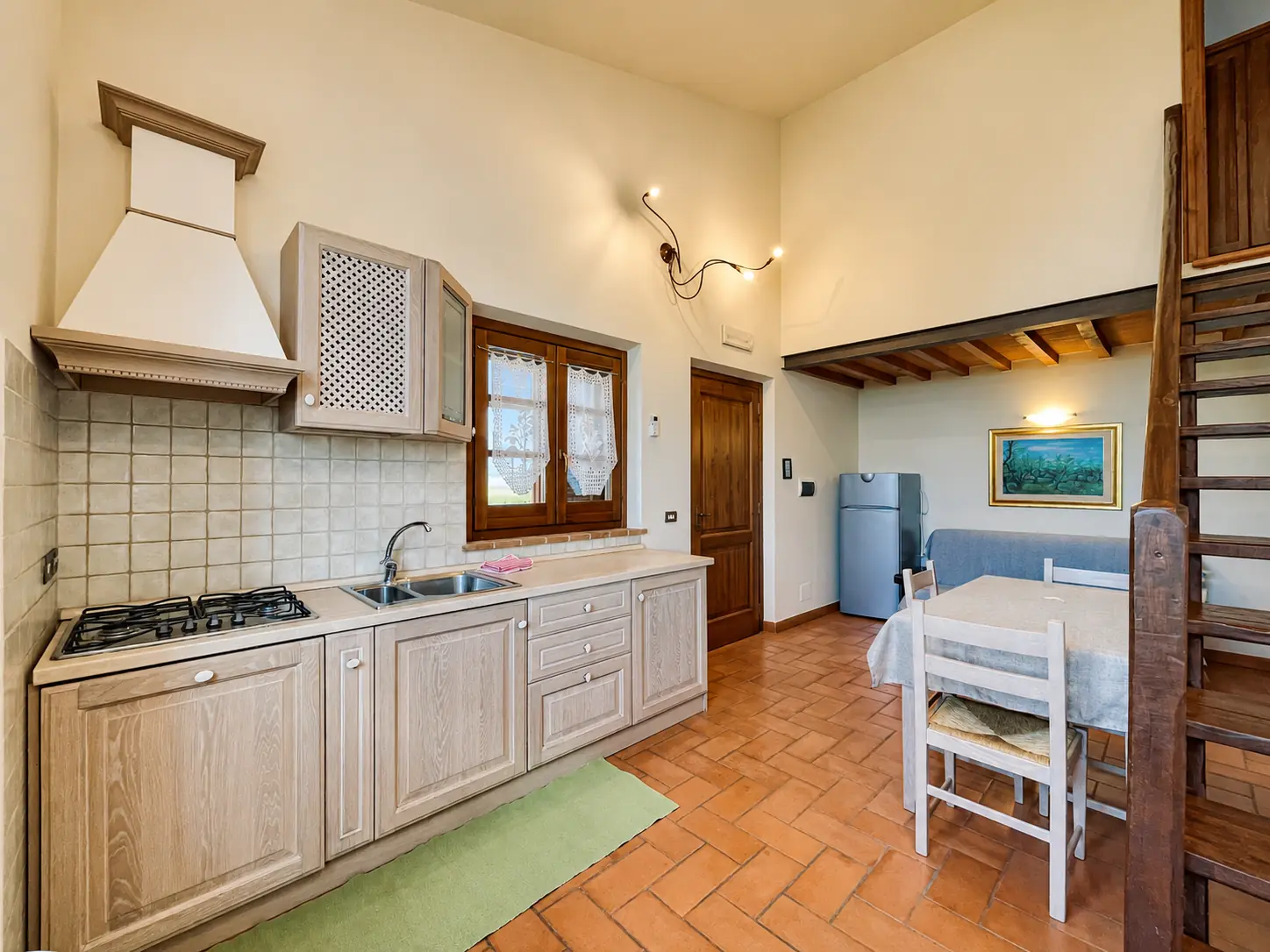 Cucina di Isola Polvese con piano cottura, lavello e zona pranzo