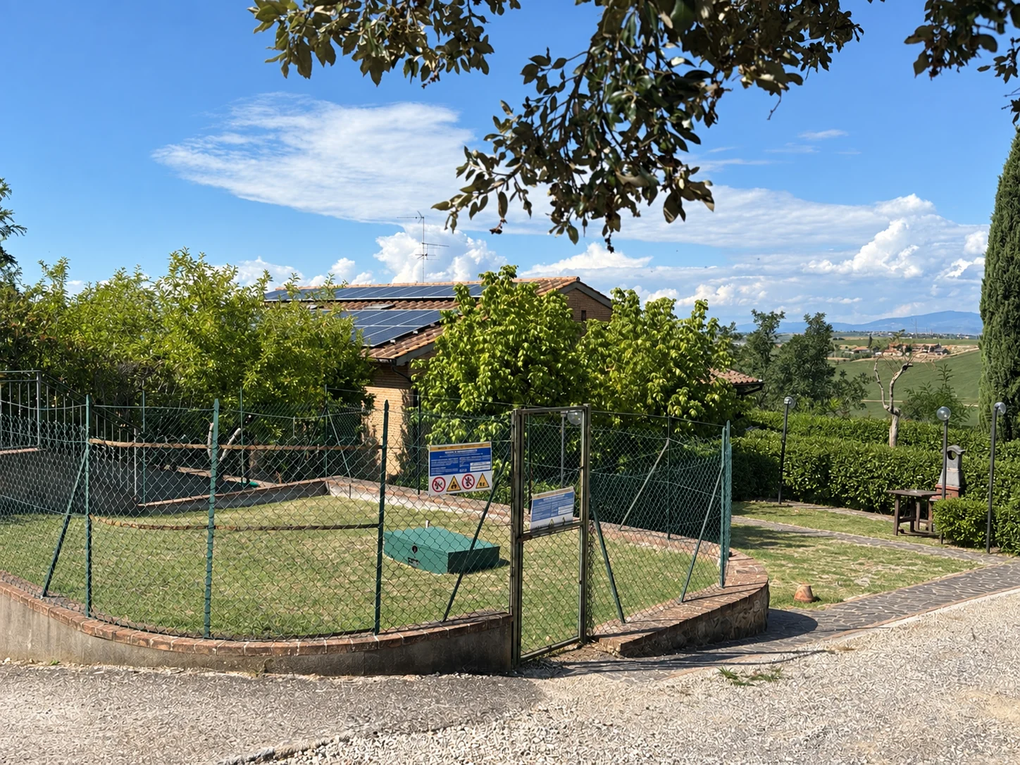 Ex capannone della Tenuta Badia a Paciano, oggi circondato dal verde, con tetto in cotto e pannelli solari