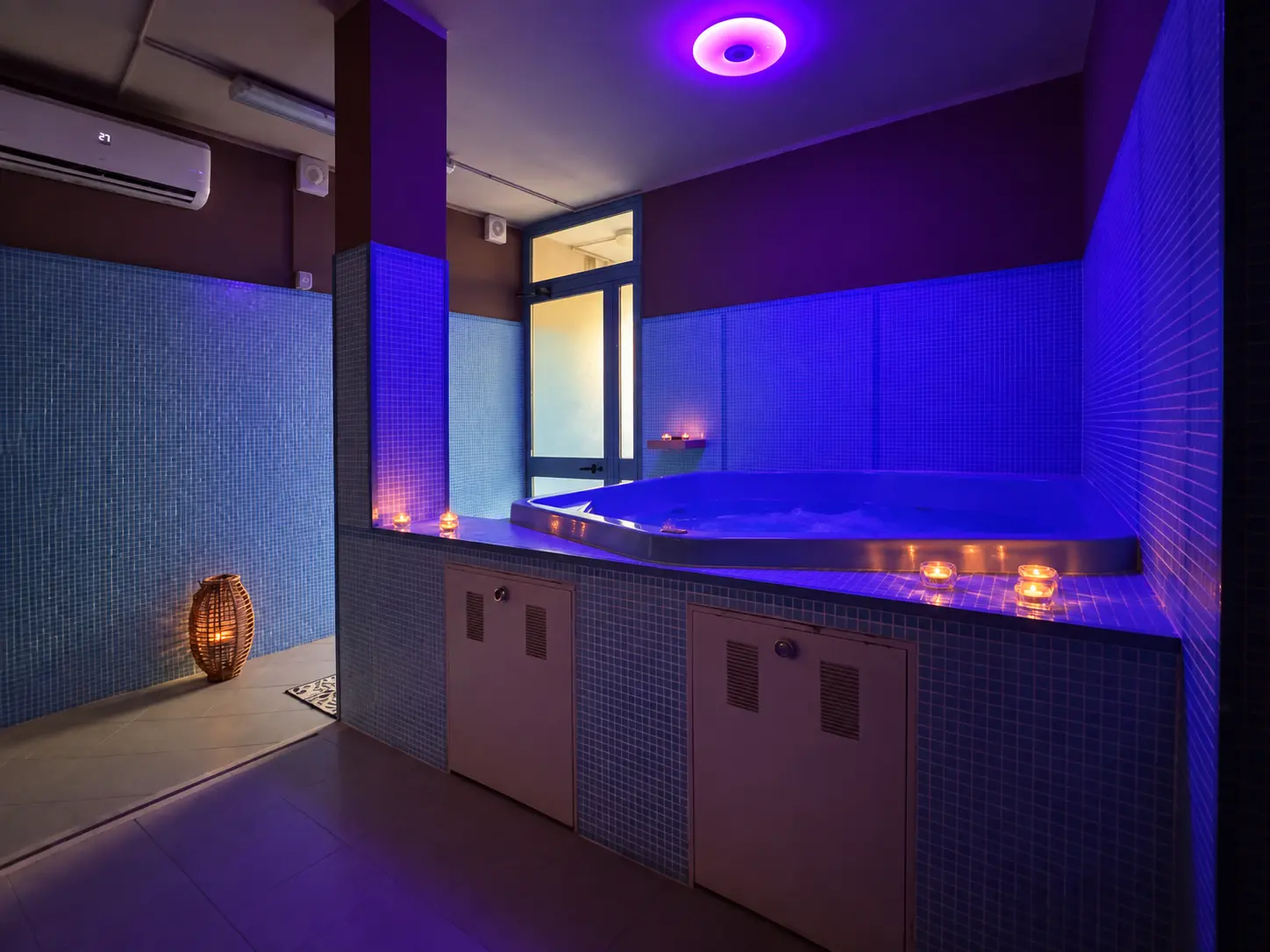 Tenuta Badia SPA hot tub lit by purple lights and candles