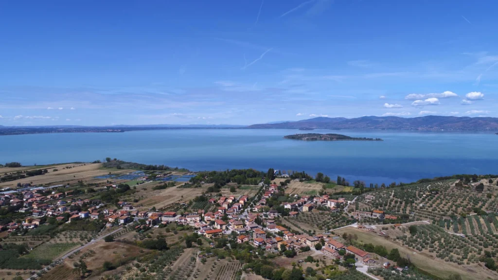 Luftaufnahme des Trasimenischen Sees mit Sant’Arcangelo vorn und Isola Polvese